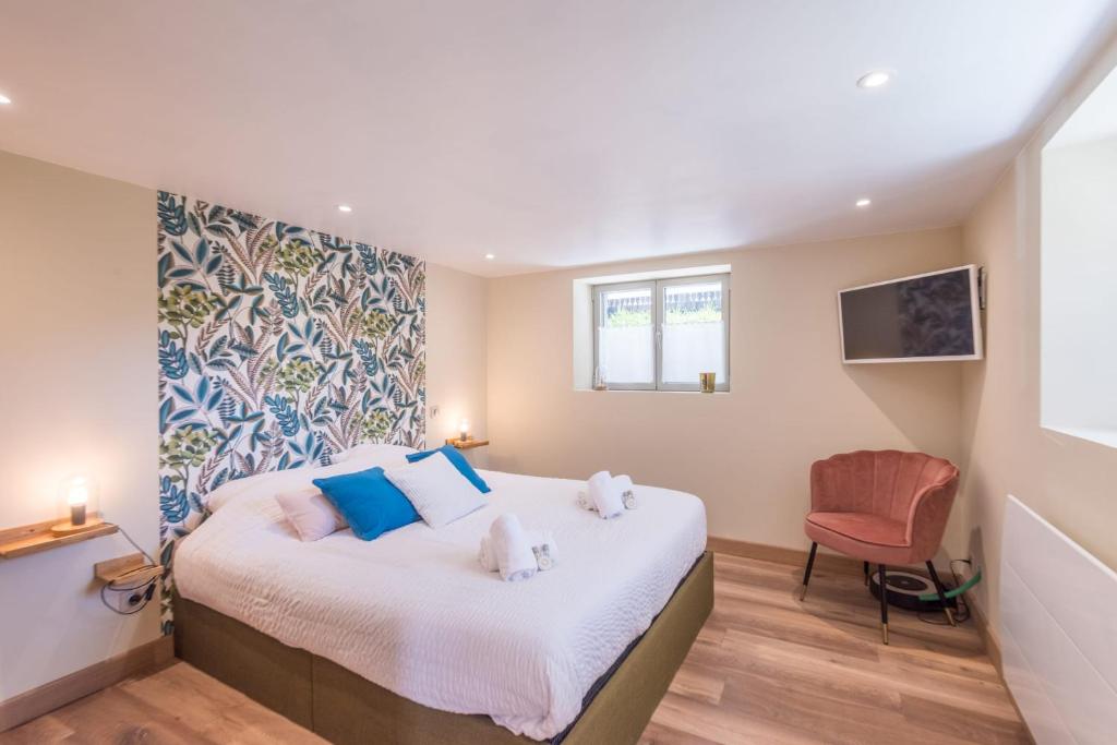 - une chambre avec un lit doté d'oreillers bleus et d'une chaise dans l'établissement Appartement Couttet - Welkeys, à Chamonix-Mont-Blanc