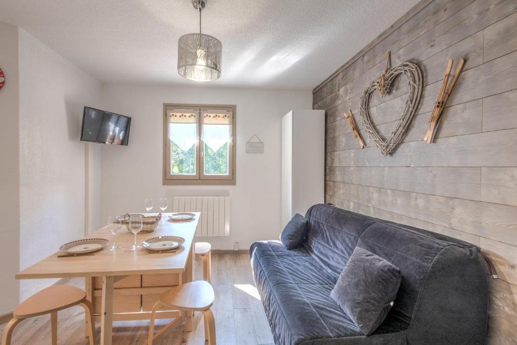 un salon avec un canapé bleu et une table dans l'établissement Studio Dryades - Mont Blanc view - Welkeys, aux Houches