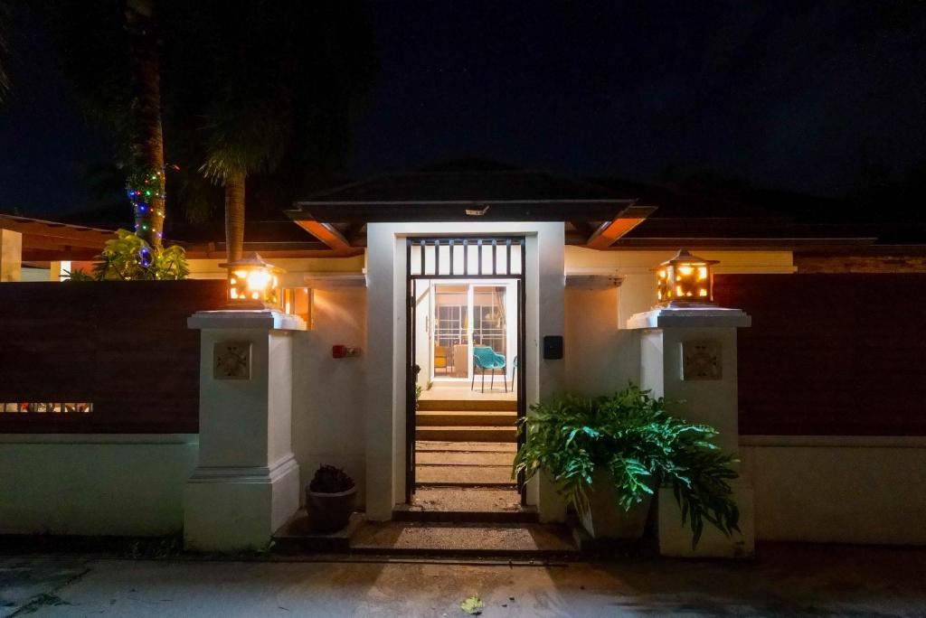 une porte d'entrée d'une maison la nuit dans l'établissement Luxurious large size swimming pool villa in Rawai, à Ban Saiyuan (1)