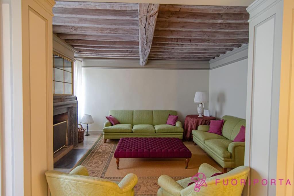 a living room with two green couches and a fireplace at Le Belle Époque in Parma