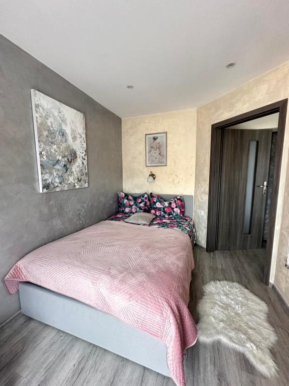 a bedroom with a bed with a pink blanket at Apartament U Bartusia in Zakopane