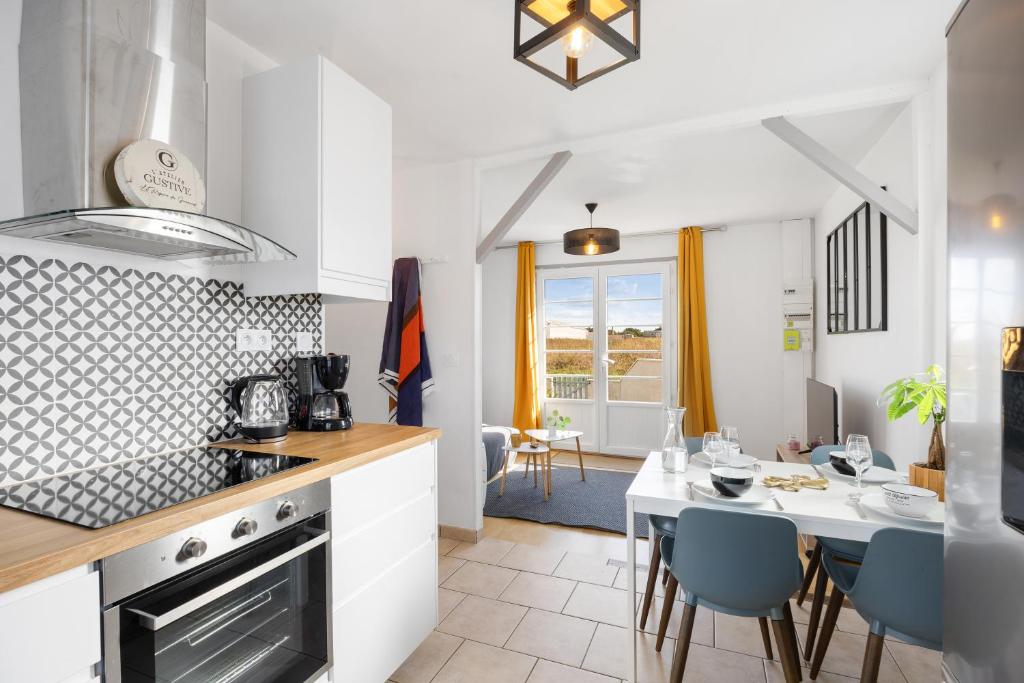 une cuisine et une salle à manger avec une table et des chaises dans l'établissement La Petite Maison, aux Sorinières