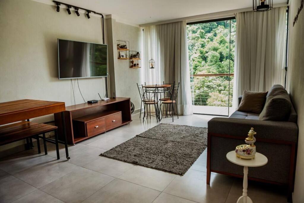ein Wohnzimmer mit Couch und Flachbildfernseher in der Unterkunft Casa Dinamarca in Santa Teresa