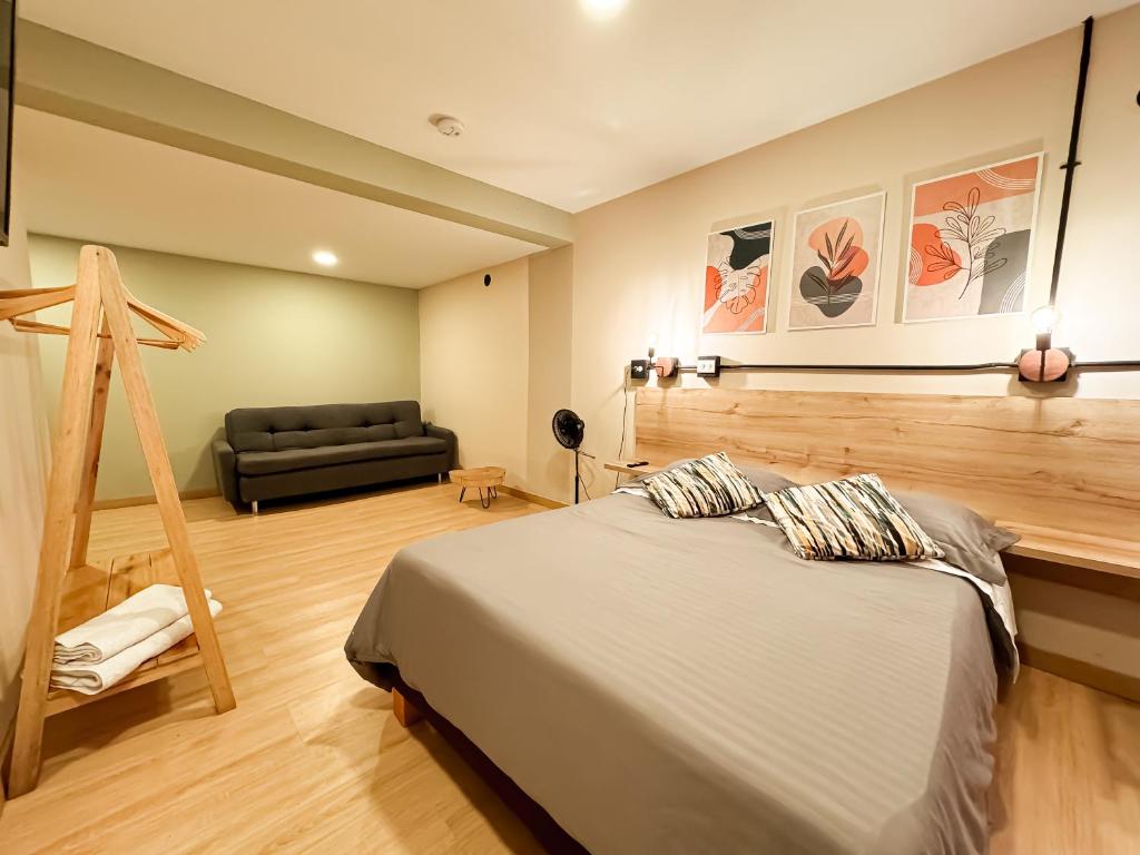 a bedroom with a bed and a couch at Hospedaje cerca de Plaza Mayor en Medellín NID102 By Roots Rentals in Medellín