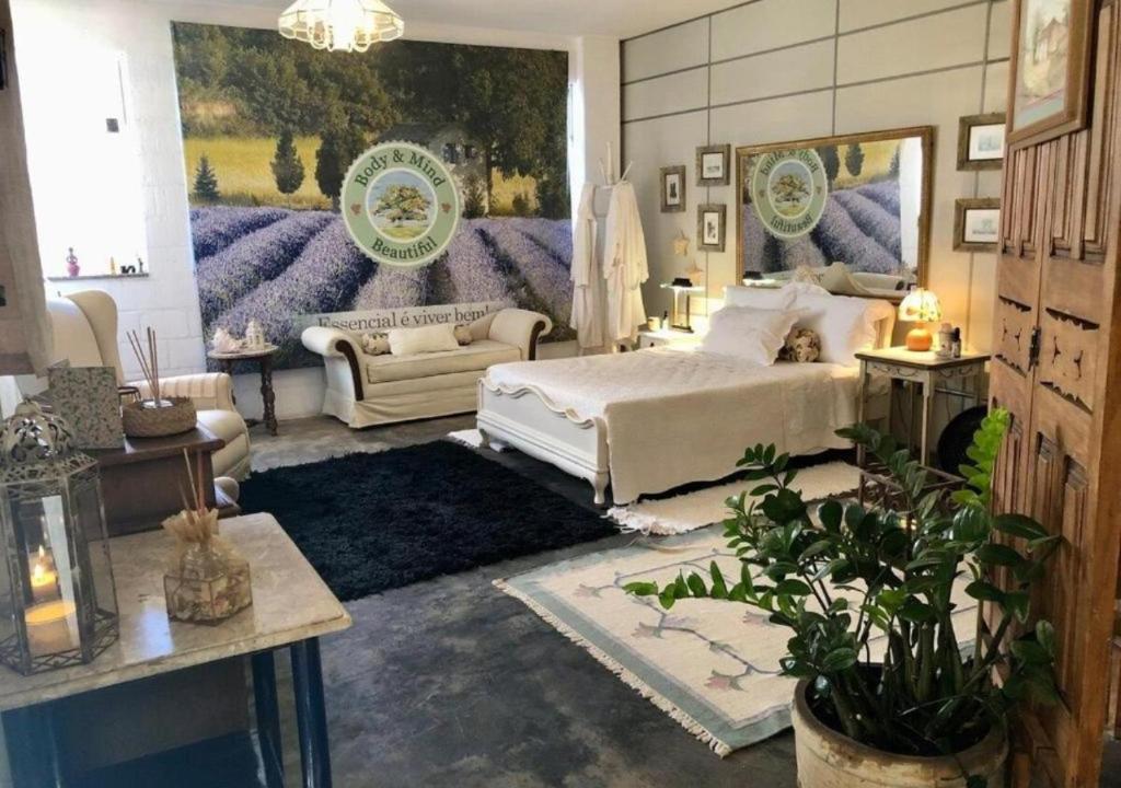 Un dormitorio con una cama, un sofá y una mesa. en Body & Mind Beautiful - Suites Elegantes e Charmosas, en Franca