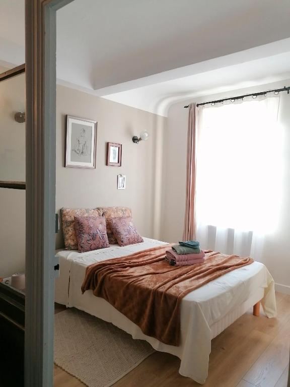 une chambre avec un lit et une grande fenêtre dans l'établissement Charmante suite indépendante en maison de village, à Loriol-sur-Drôme