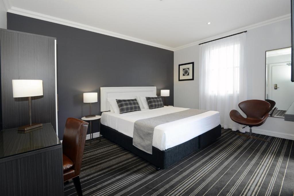 a bedroom with a bed and a desk and a chair at Perouse Randwick by Sydney Lodges in Sydney