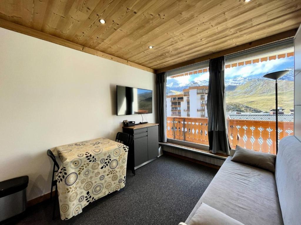 Cette chambre comprend un lit et une grande fenêtre. dans l'établissement Résidence Dome De Polset - VAL THORENS location: studio rénové et ensoleillé avec vue sur les montagnes MAE-9125, à Val Thorens