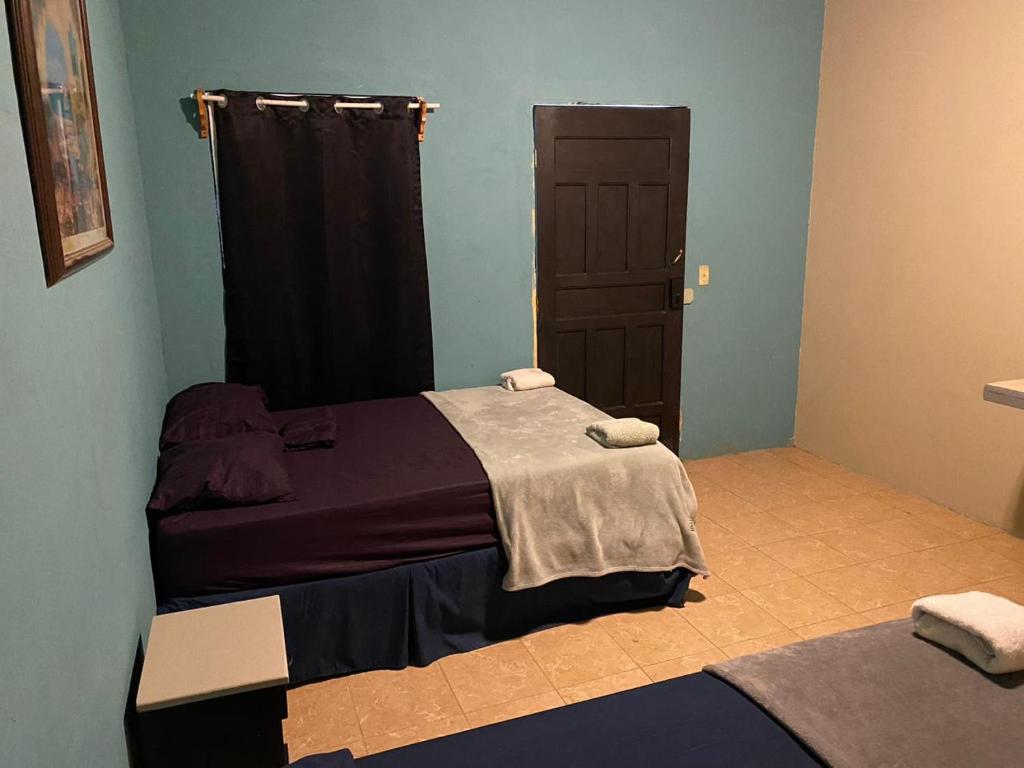 a bedroom with a bed and a door with towels at Airport Inn Roatan in Coxen Hole