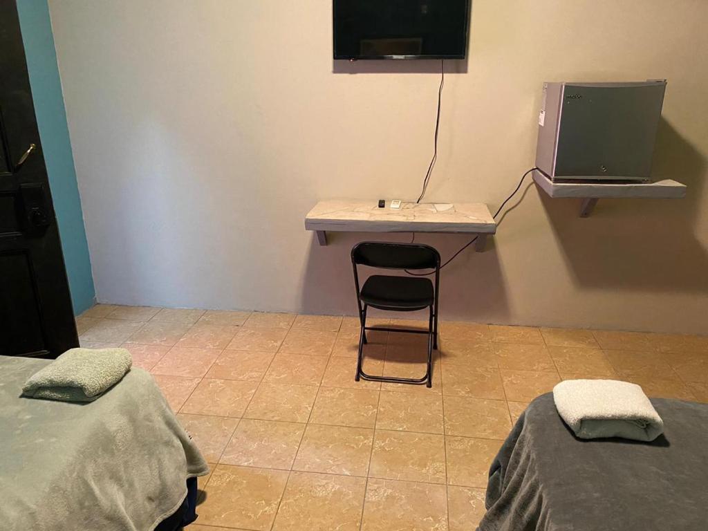 a room with a desk with a chair and a computer at Airport Inn Roatan in Coxen Hole