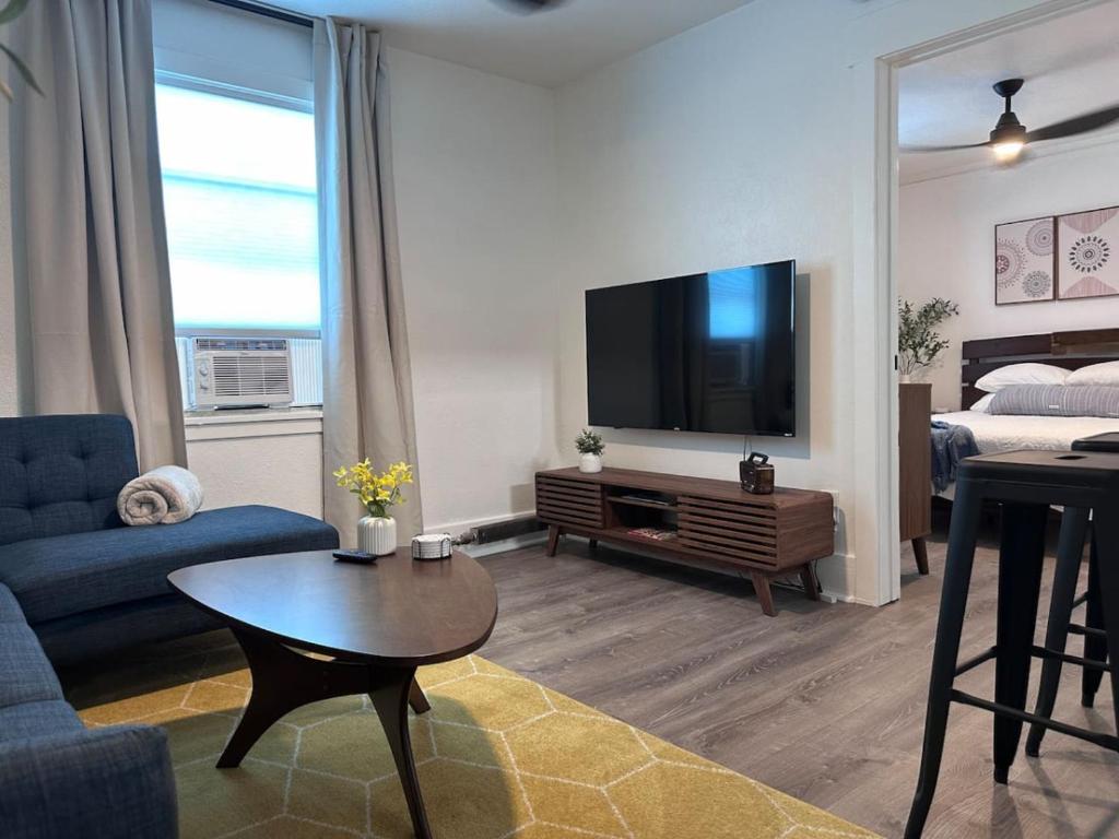 a living room with a blue couch and a tv at Modern Unit 313 at The George in Klamath Falls