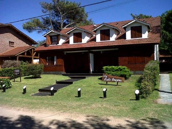 una casa con un banco delante de ella en Los Cuatro Corazones en Villa Gesell