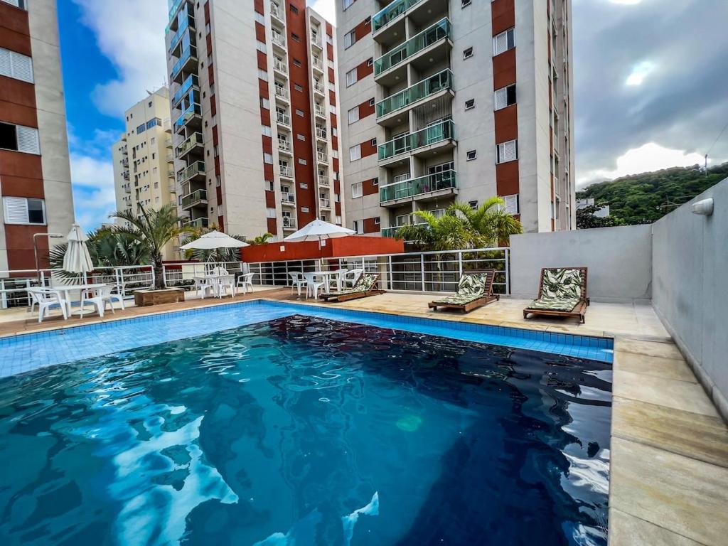 a swimming pool in a hotel with buildings at R7 Conforto total com piscina in Guarujá