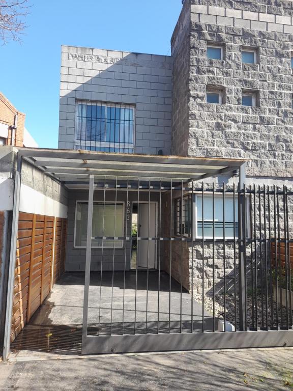 a house with a gate in front of a building at Luna de Valencia in Mar del Plata