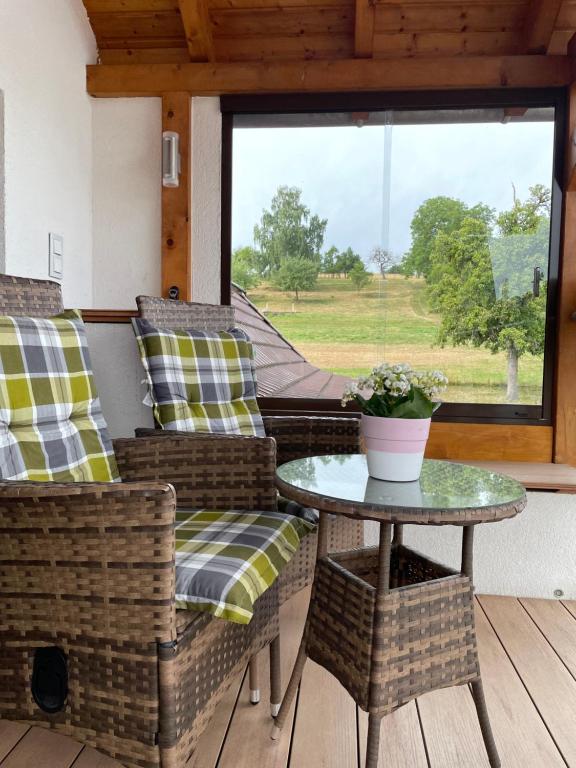 a porch with chairs and a table and a window at Roomfortwo Natural in Waldsolms