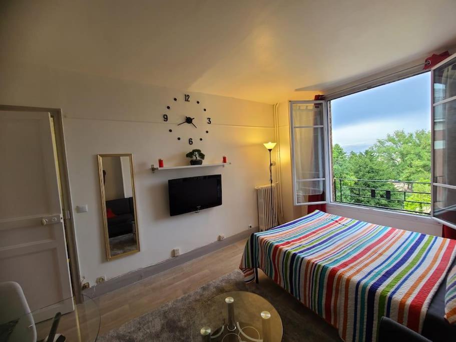 une chambre avec un lit et une horloge au mur dans l'établissement 19eme studio, à Paris