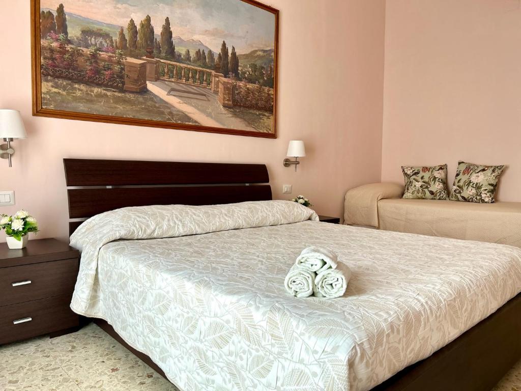 a bedroom with two beds and a painting on the wall at Casa Vacanze Le Fontane in Tivoli