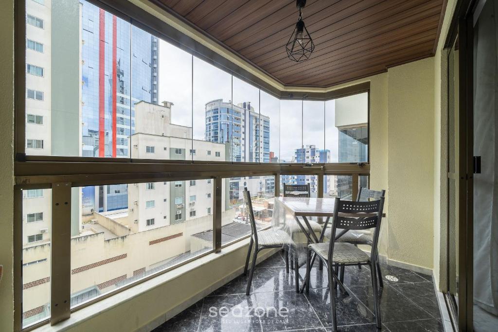 a balcony with a table and chairs and a view of the city at Apto em otima localização em Meia Praia EIO6031 in Meia Praia