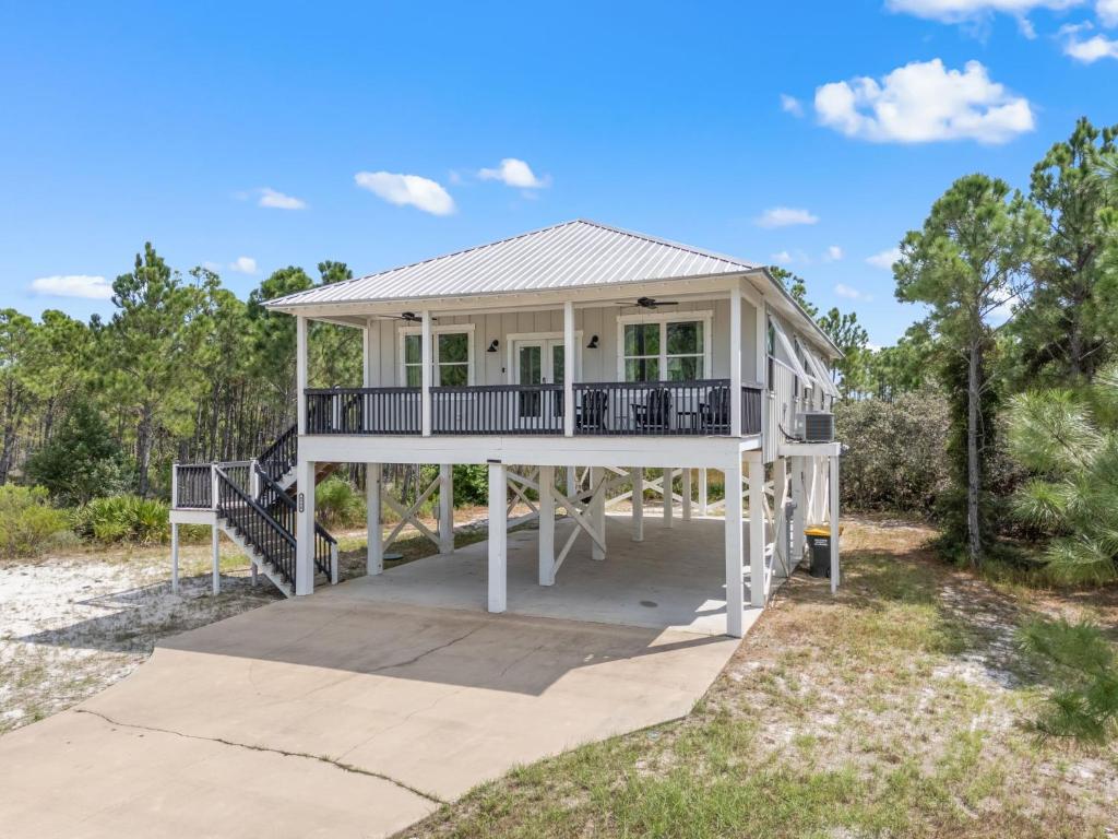 a house on the beach with a porch at Beach Please in Gulf Shores