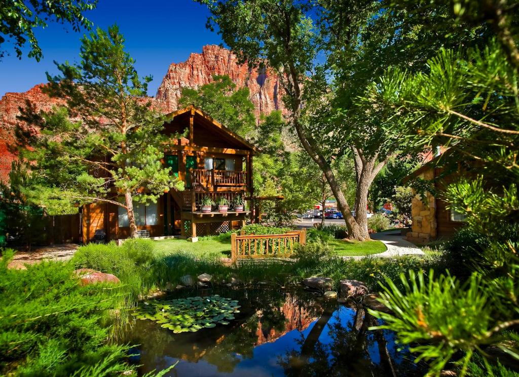 a house with a pond in front of a mountain at Flanigan`s Resort and Spa in Springdale