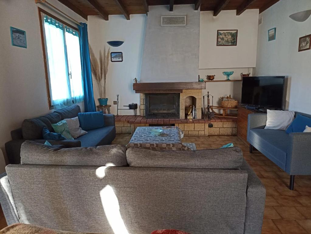 un soggiorno con due divani e un camino di Maison de charme à Fontrabiouse avec vue sur la montagne a Fontrabiouse
