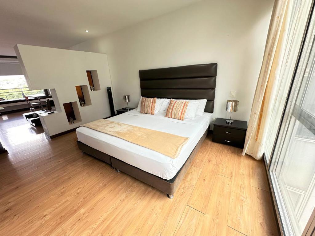 a bedroom with a large bed and a piano at M402- Apartaestudio tipo loft en el norte (Av 19) in Armenia
