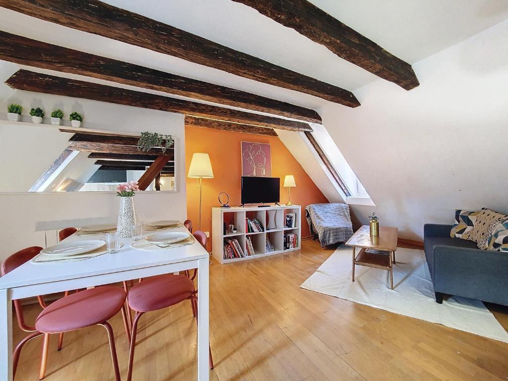 un salon avec une table et des chaises blanches dans l'établissement TONNEAU - Hypercentre - Cathédrale - Authentique - Duplex, à Strasbourg