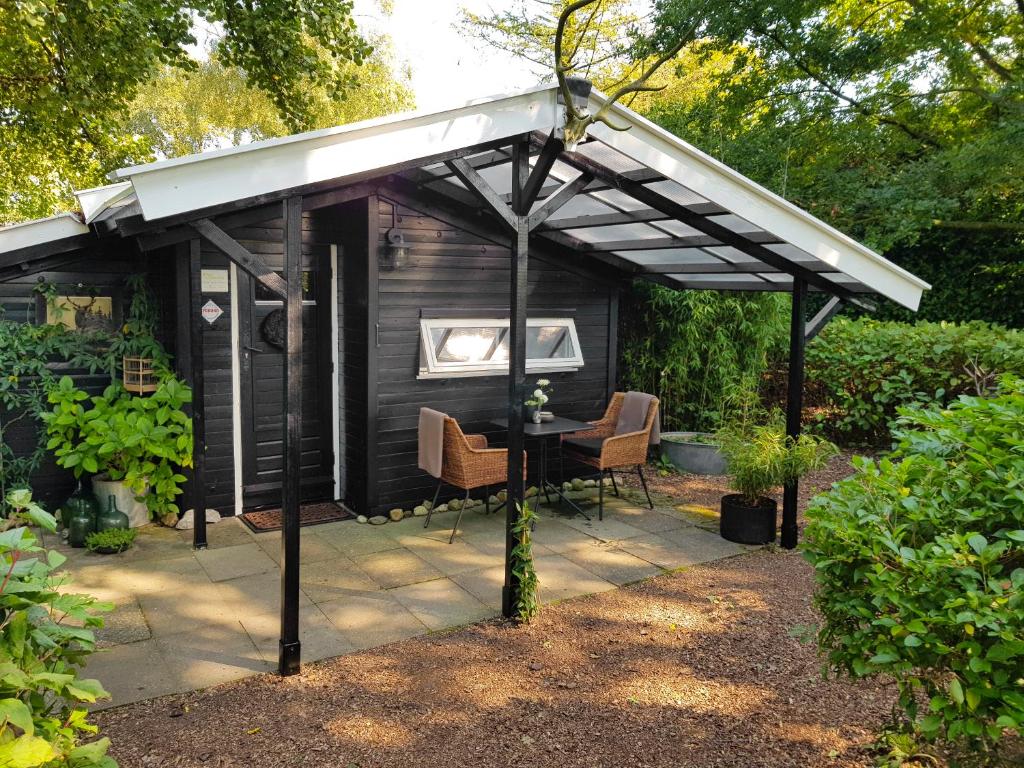 a pergola over a table in a garden at Natuurhuisje 't Poepekrus in Kootstertille