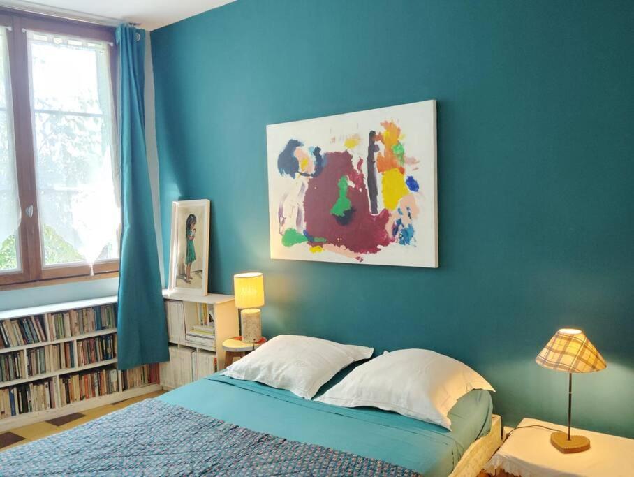 - une chambre dotée d'un mur bleu avec un lit et une lampe dans l'établissement Maison Vintage - Clim - Wifi - Parking dans la rue, à Avignon