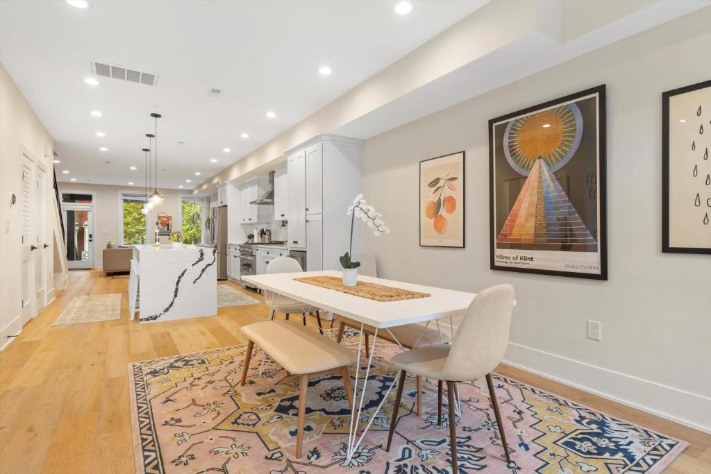 a kitchen and dining room with a white table and chairs at Central DC 5-BR Townhome - Walk to METRO-rail in Washington, D.C.