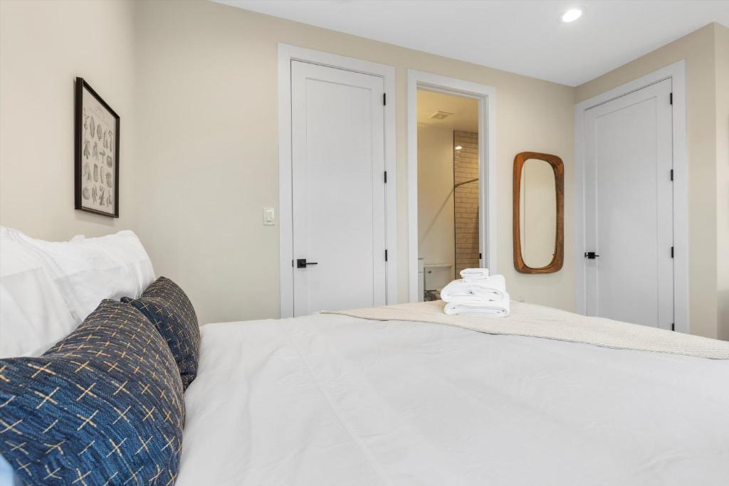 a bedroom with a large white bed with a mirror at Central DC 5-BR Townhome - Walk to METRO-rail in Washington, D.C.