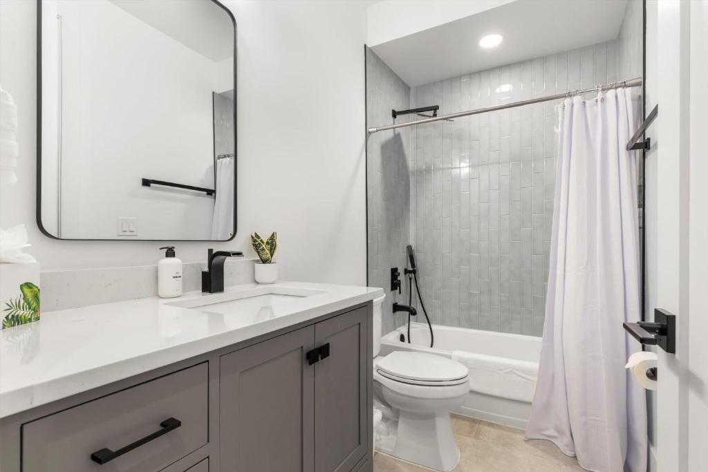 a white bathroom with a sink and a toilet at Central DC 5-BR Townhome - Walk to METRO-rail in Washington, D.C.
