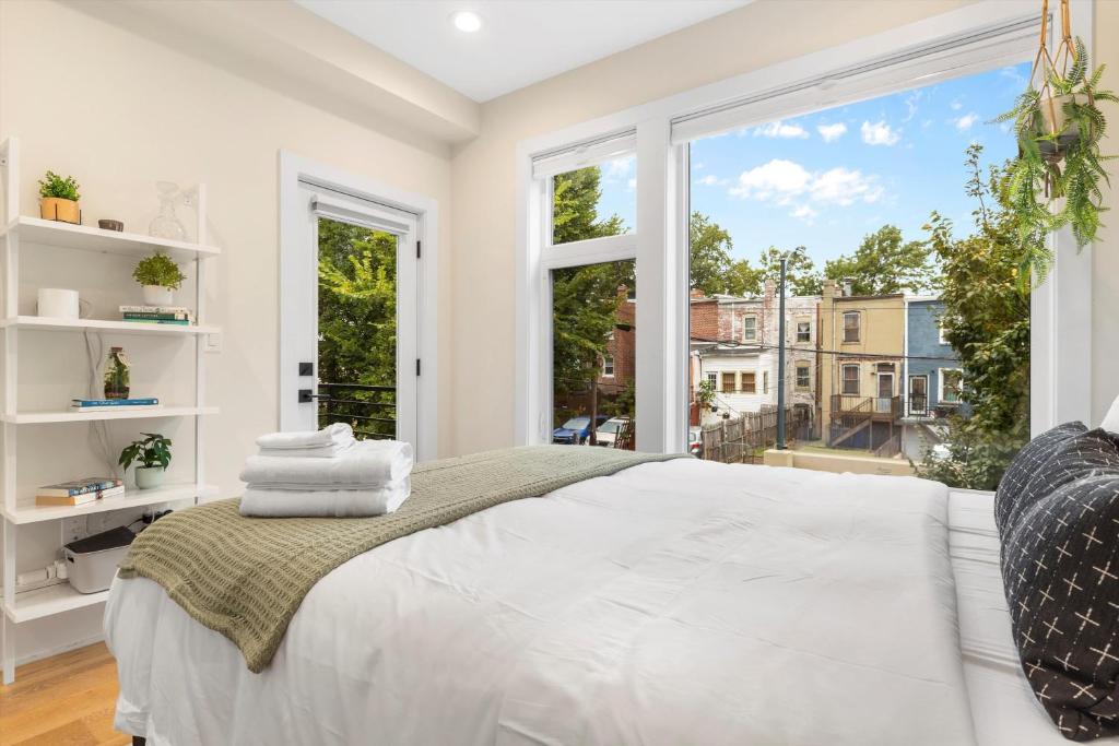 a bedroom with a bed and a large window at Central DC 5-BR Townhome - Walk to METRO-rail in Washington, D.C.