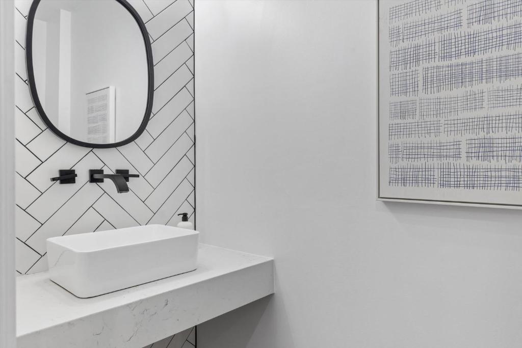 a bathroom with a white sink and a mirror at Central DC 5-BR Townhome - Walk to METRO-rail in Washington, D.C.