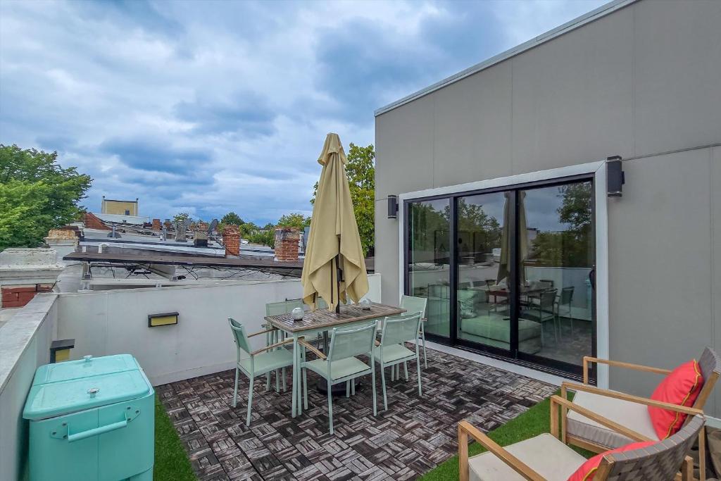 a patio with a table and chairs and a umbrella at Central DC 5-BR Townhome - Walk to METRO-rail in Washington, D.C.