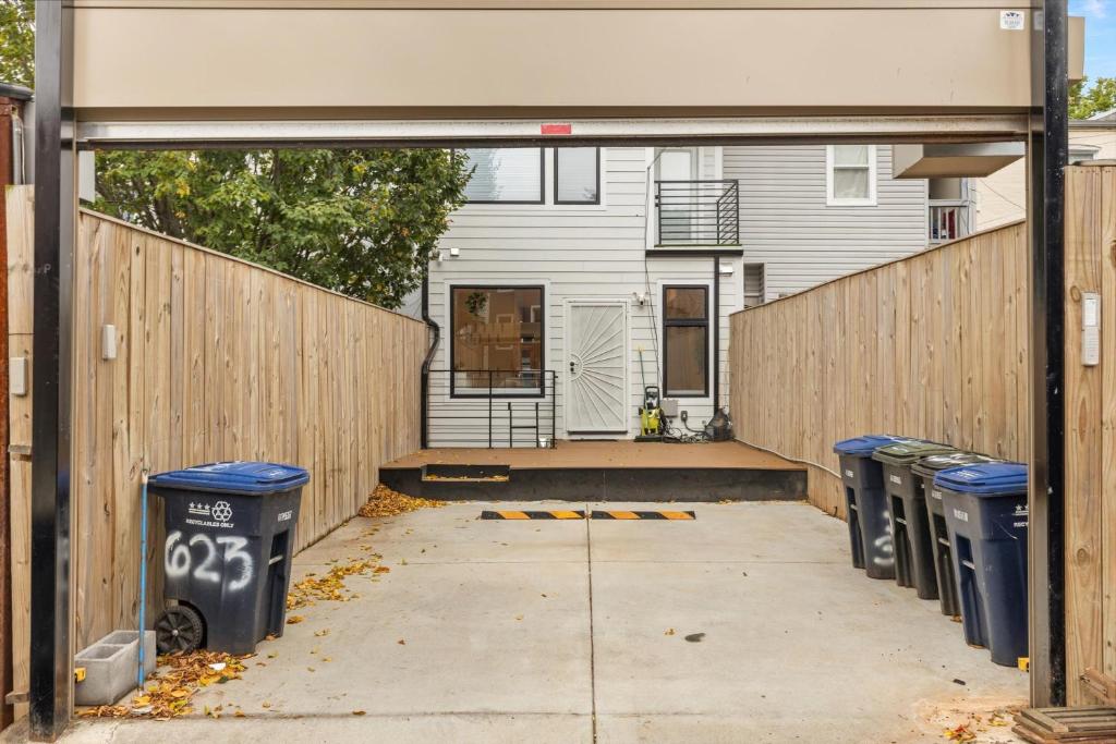 a row of trash cans in front of a fence at Central DC 5-BR Townhome - Walk to METRO-rail in Washington, D.C.