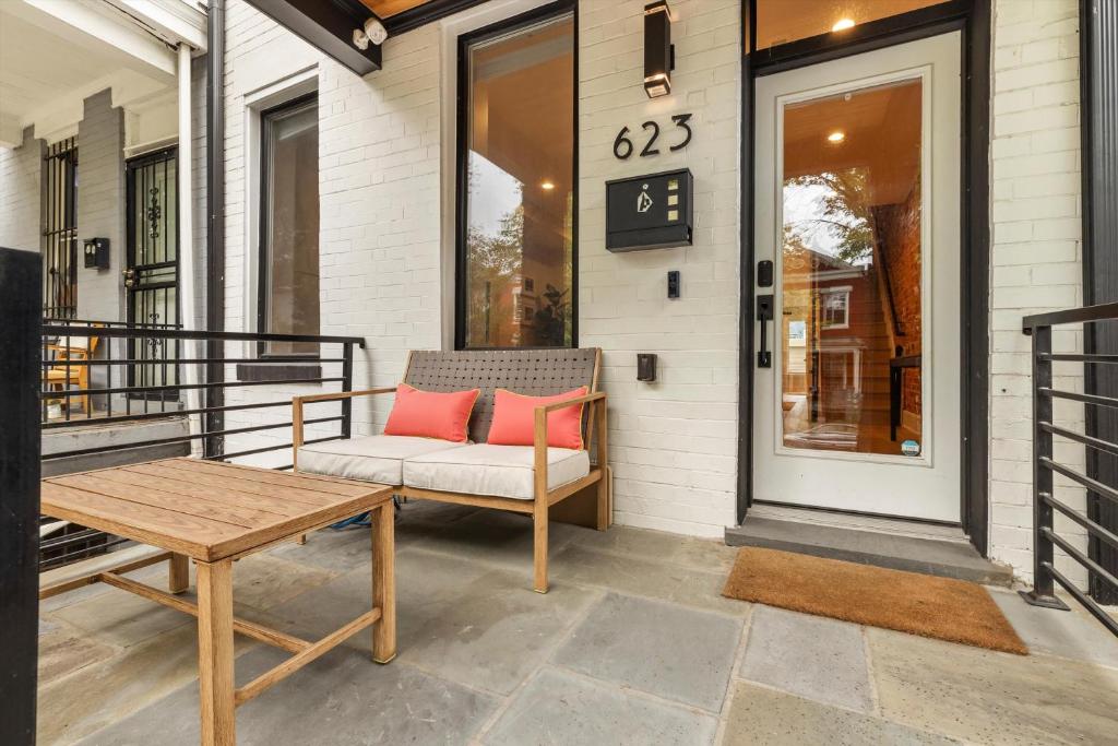a porch with a chair and a table and a clock at Central DC 5-BR Townhome - Walk to METRO-rail in Washington, D.C.