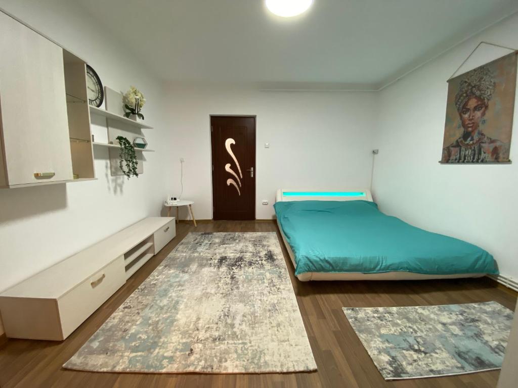 a small bedroom with a bed and a rug at Secret Studio Braila in Brăila