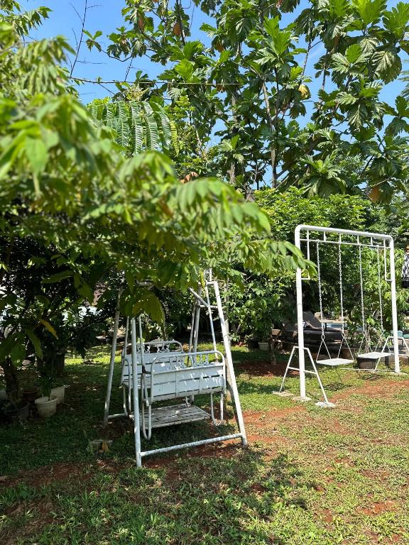 a swing set in a garden under a tree at Little Bali Villa - Luxury Lake View at Bogor in Kalisuren 2