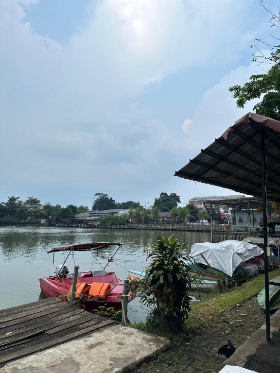 a boat is docked next to a dock at Little Bali Villa - Luxury Lake View at Bogor in Kalisuren 2
