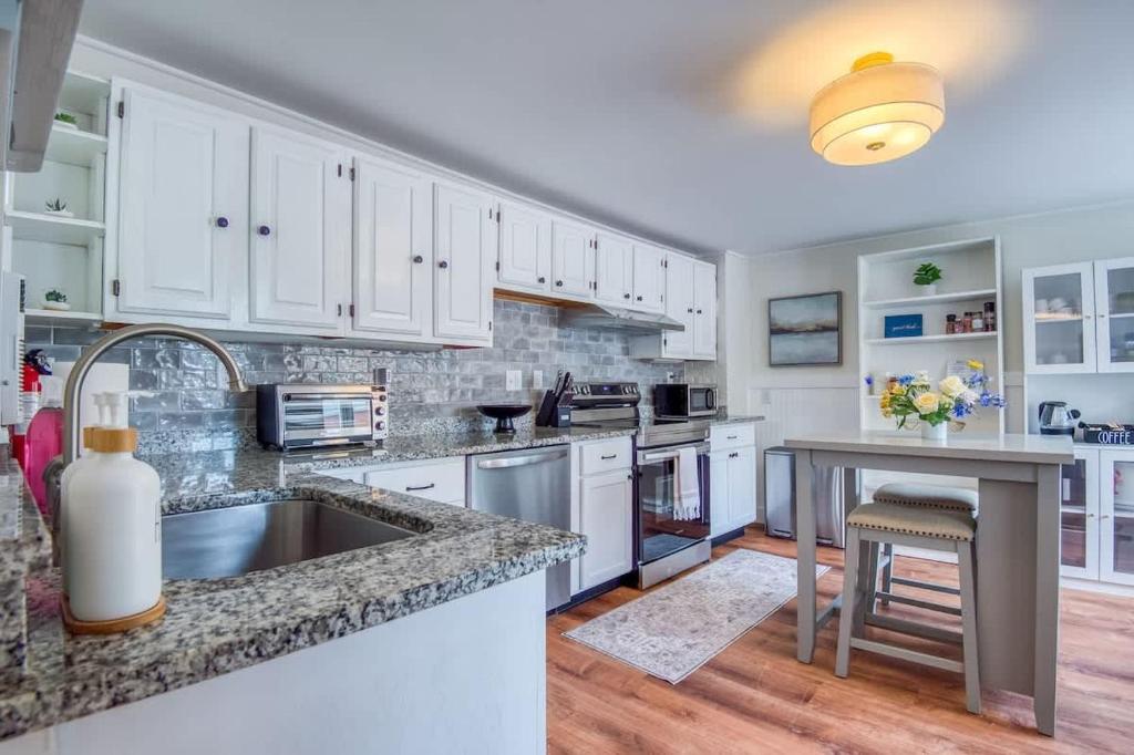 a kitchen with white cabinets and a granite counter top at Spacious 6BR close to Portsmouth beaches and UNH in Dover