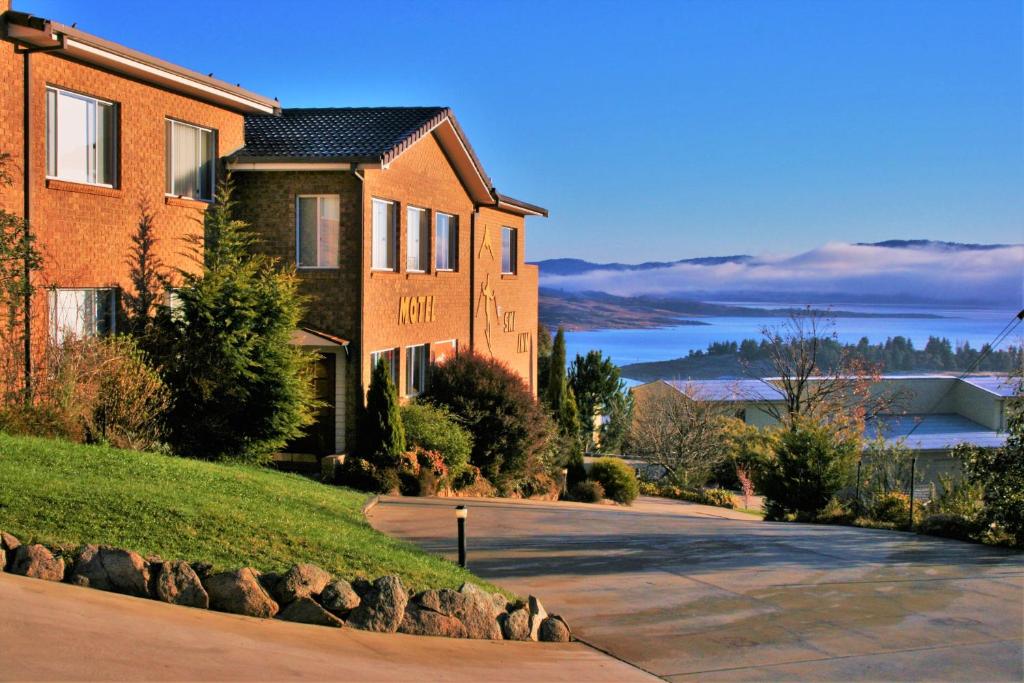 a brick house with a driveway in front of it at Panorama Jindabyne in Jindabyne