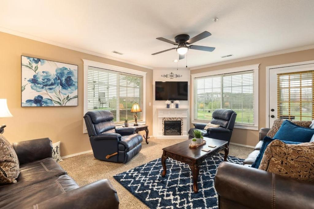 a living room with leather furniture and a fireplace at Little House on the 12th Hole - Luxury Golf Condo in Branson