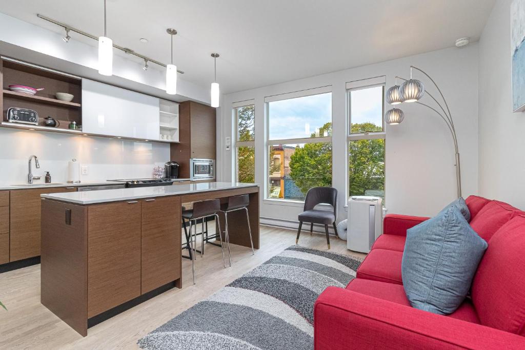 a living room with a red couch and a kitchen at Sleek Kitchen Island And Garden Views in Victoria