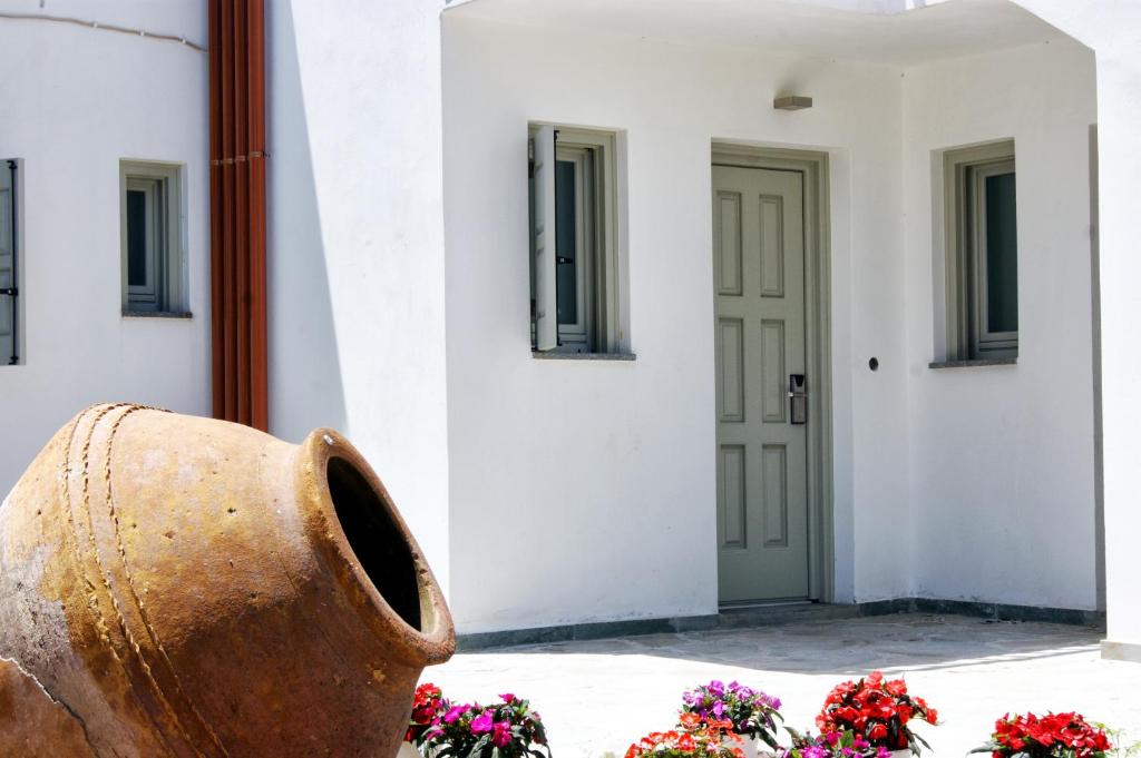a vase in front of a white building with flowers at Cascade Holiday Resort in Poros