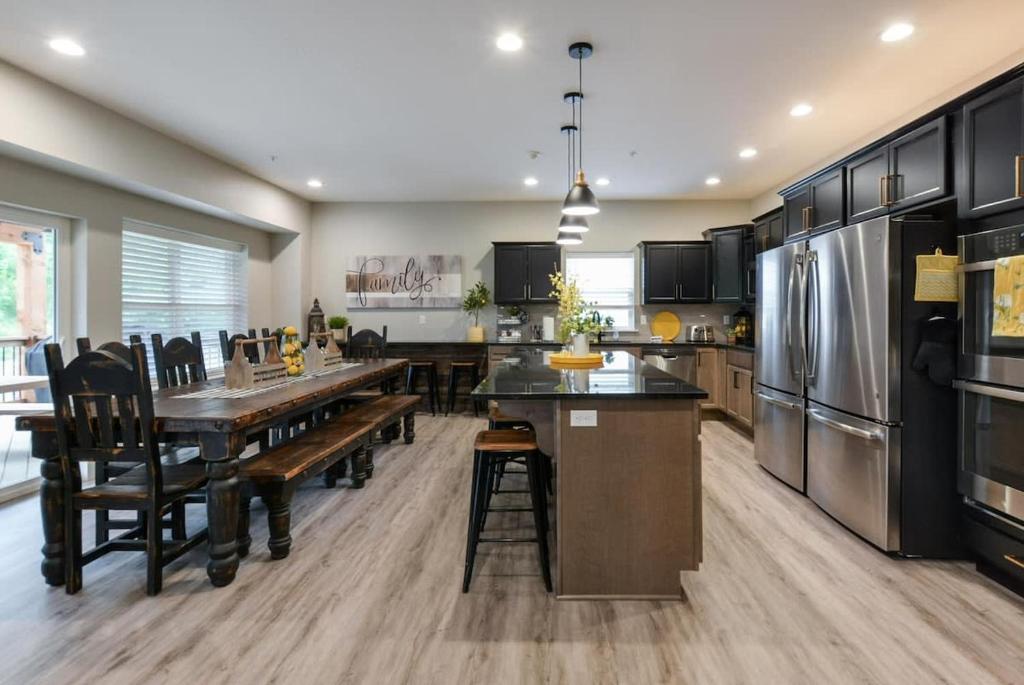 a large kitchen with a table and a refrigerator at Livin' The Dream- Indoor Outdoor pool & Private Hot Tub in Branson