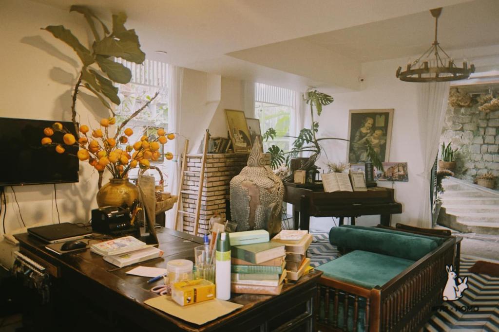 a cluttered living room with a table and a piano at D Home Da Lat 4 in Da Lat