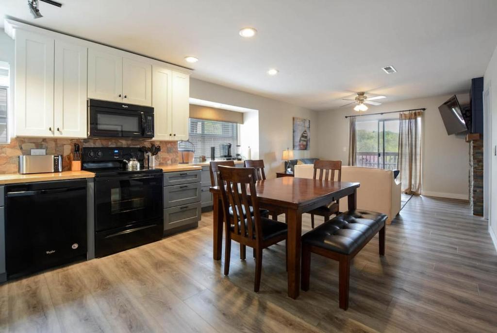 a kitchen with a wooden table and a dining room at Libby's Perch No Stairs Outdoor Pool in Branson