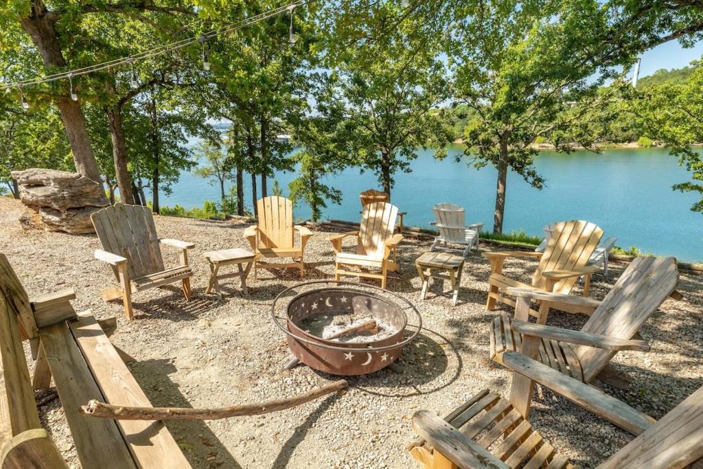 - un groupe de chaises et un foyer extérieur à côté d'un lac dans l'établissement Artilla Cove Cabin 2 - Lake views - Outdoor pool, à Branson
