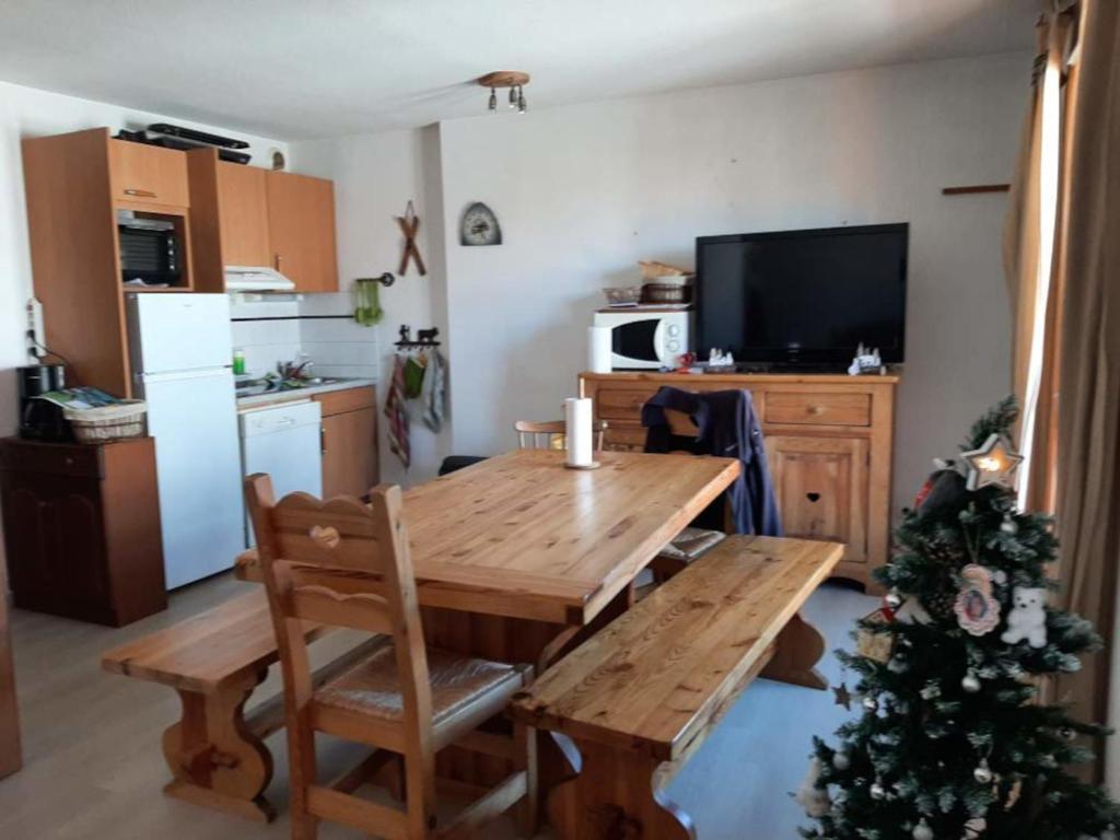 une cuisine avec une table en bois et un sapin de Noël dans l'établissement Albiez-Montrond, appt 70m2, 4 pièces, 10 pers, équipement bébé - FR-1-618-38, à Albiez-Montrond